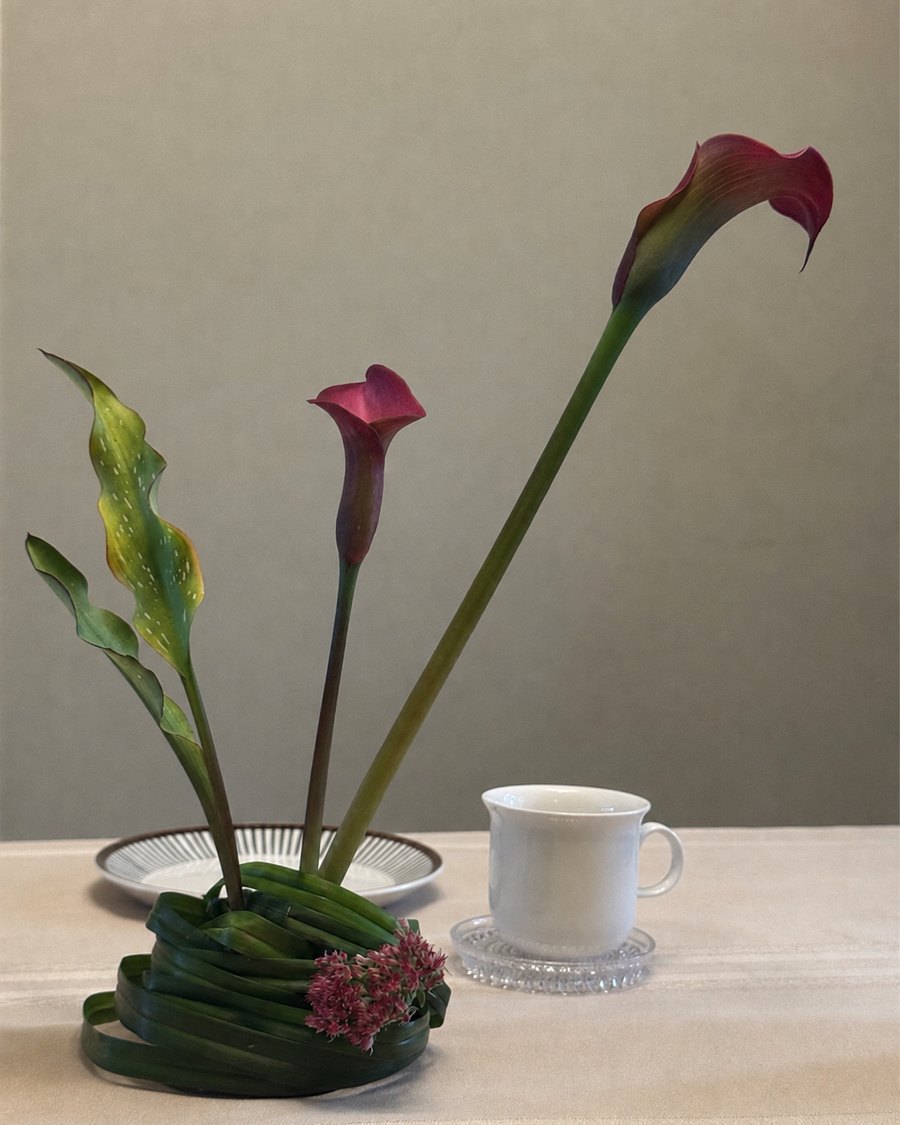 The coiled piece set on a table dressed in unbleached linen, beside a single cup and plate.